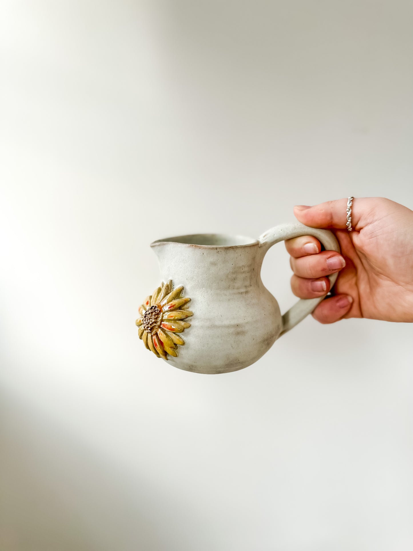 Studio pottery creamer with sunflower